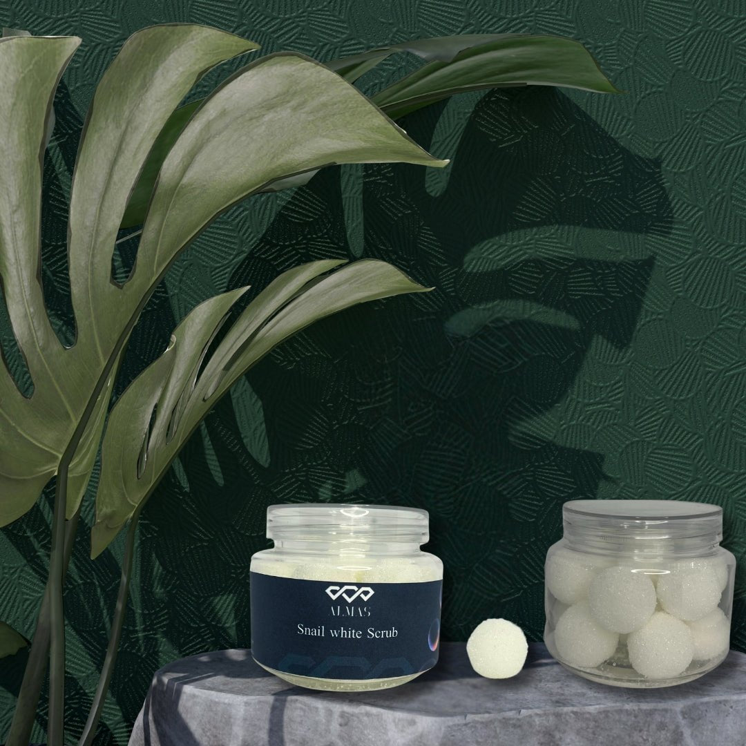 سكراب الحلزون الأبيض موضوعة على طاولة مع نباتات خضراء خلفية، يظهر طبيعة المنتج وجماله.